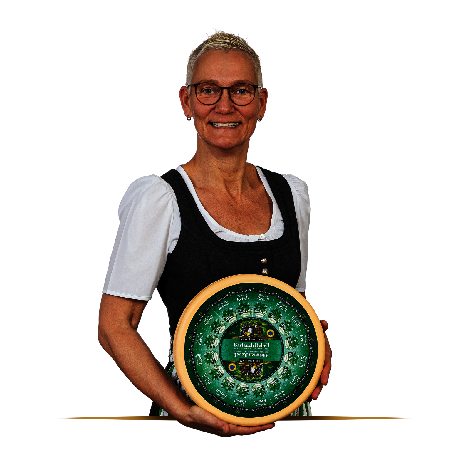 Lachende Frau in Dirndl mit einem Laib Käse in der Hand.