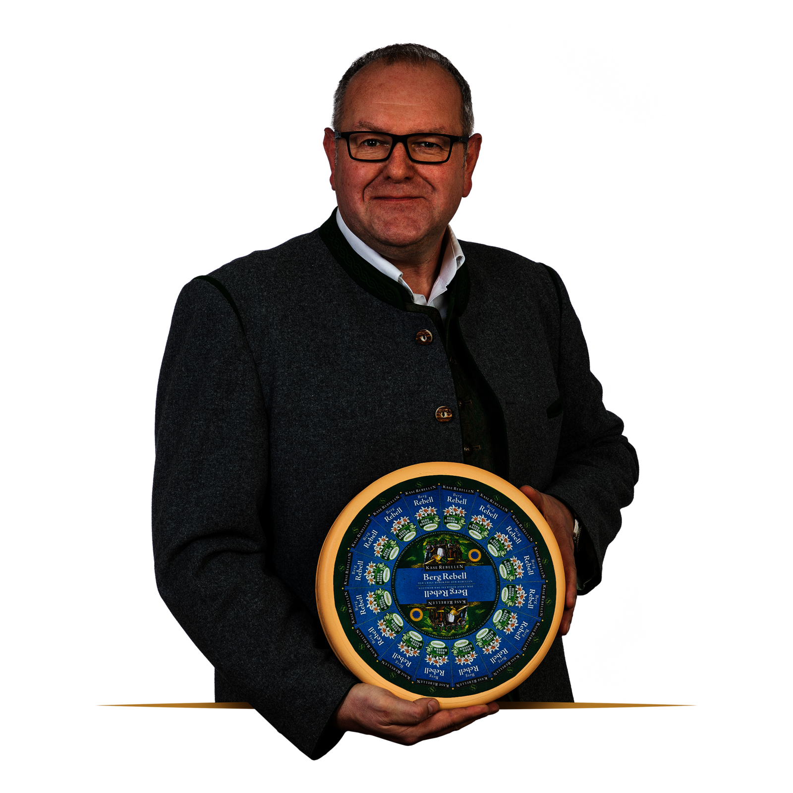 Lachender Mensch in Tracht mit einem Laib Käse in der Hand.