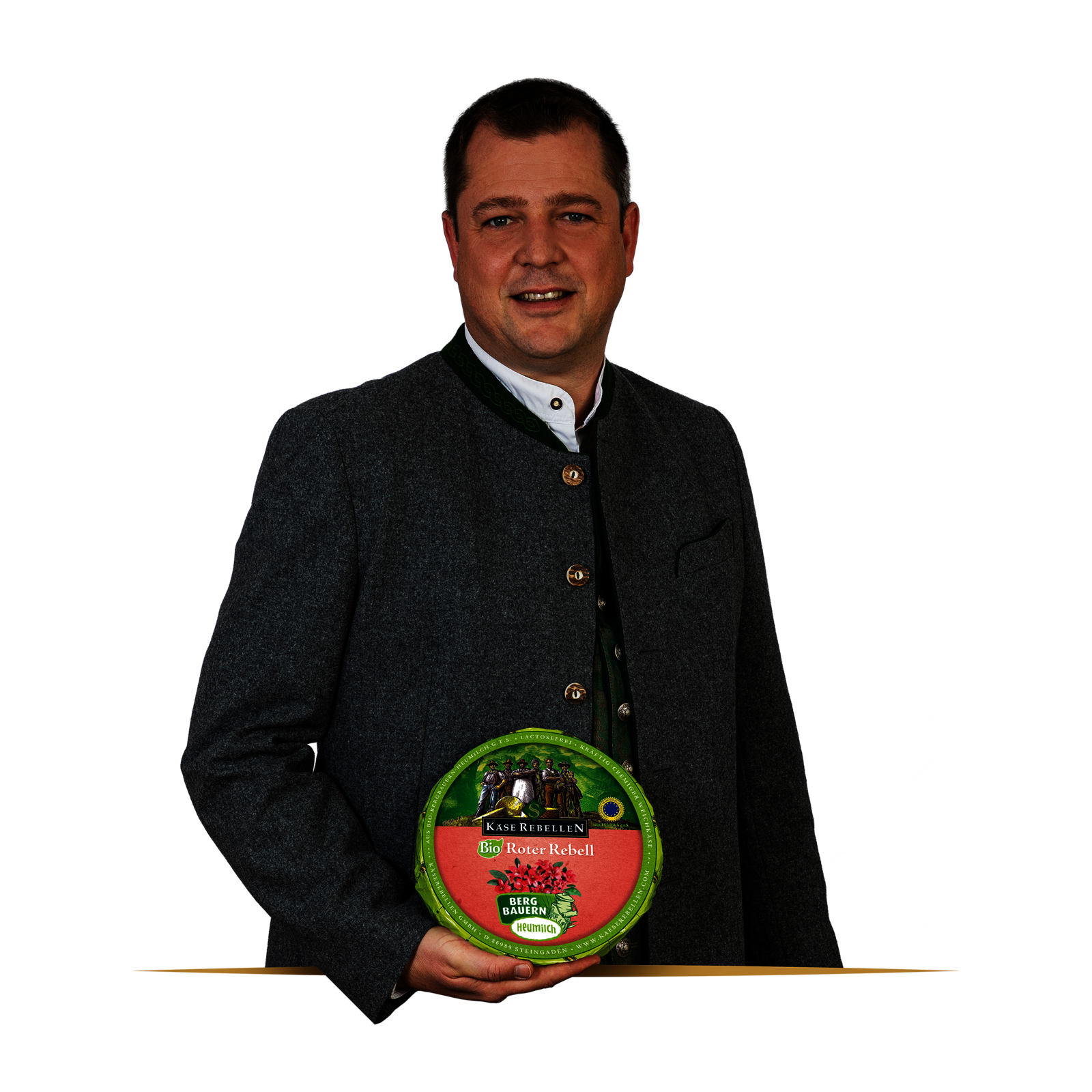 Lachender Mensch in Tracht mit einem Laib Käse in der Hand.
