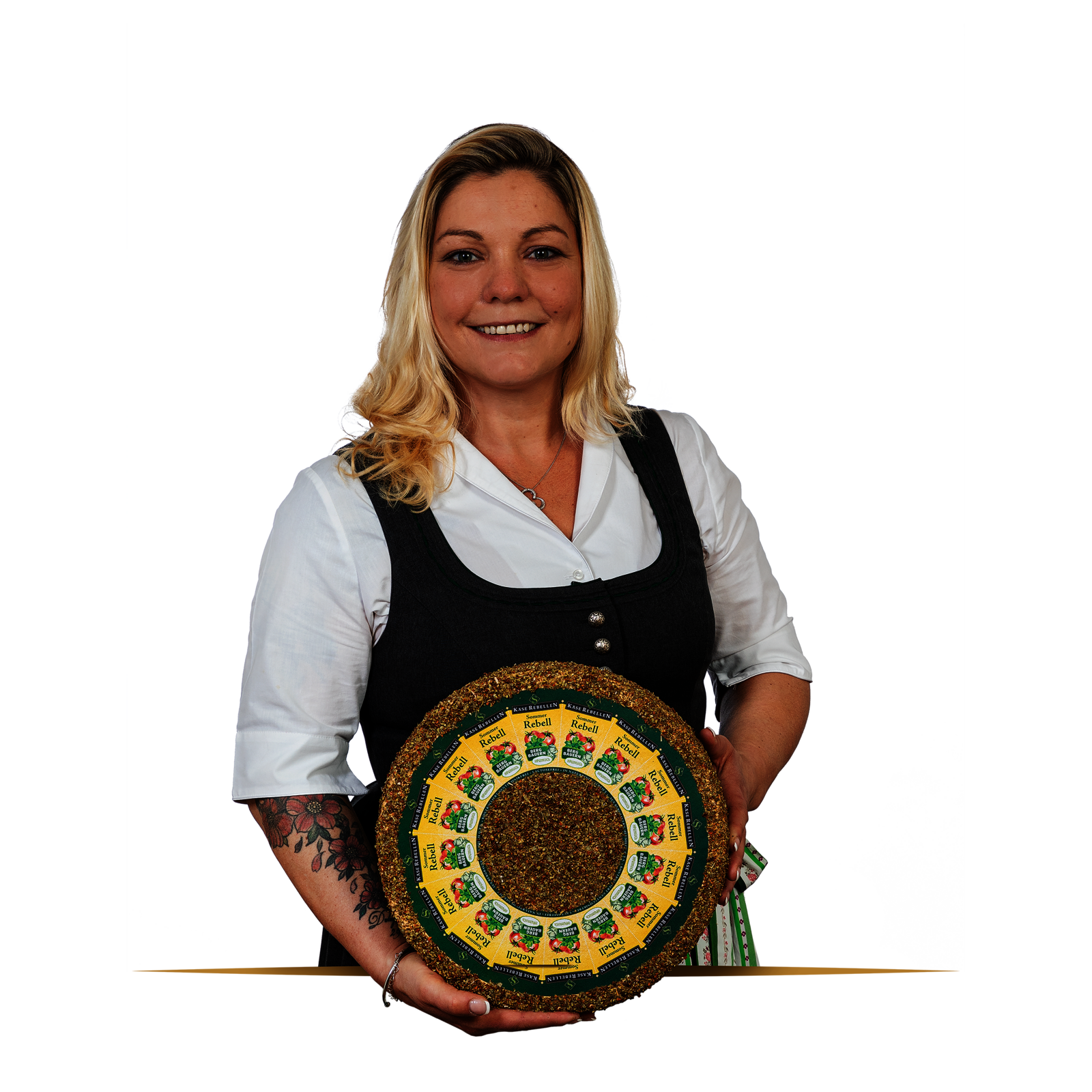 Lachende Frau in Dirndl mit einem Laib Käse in der Hand.