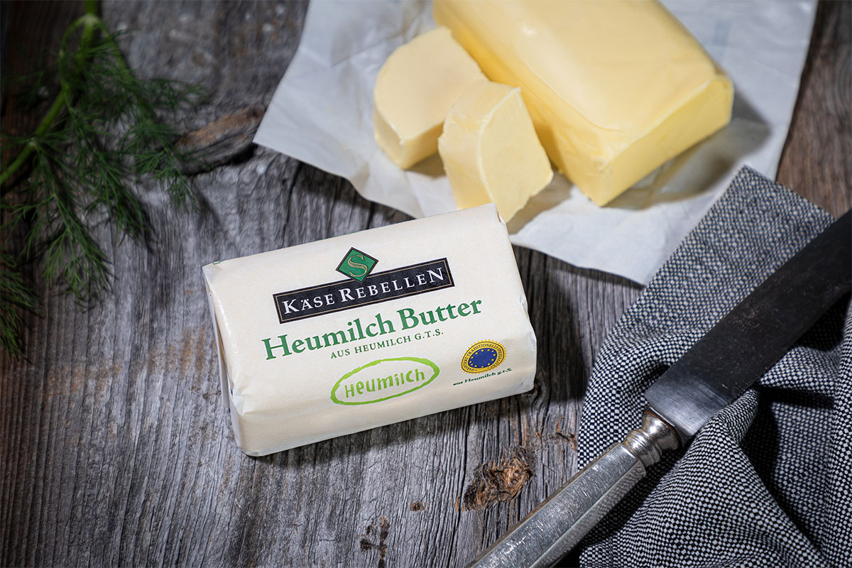 Sauerrahmbutter verziert mit urigem Messer auf Holzbrett