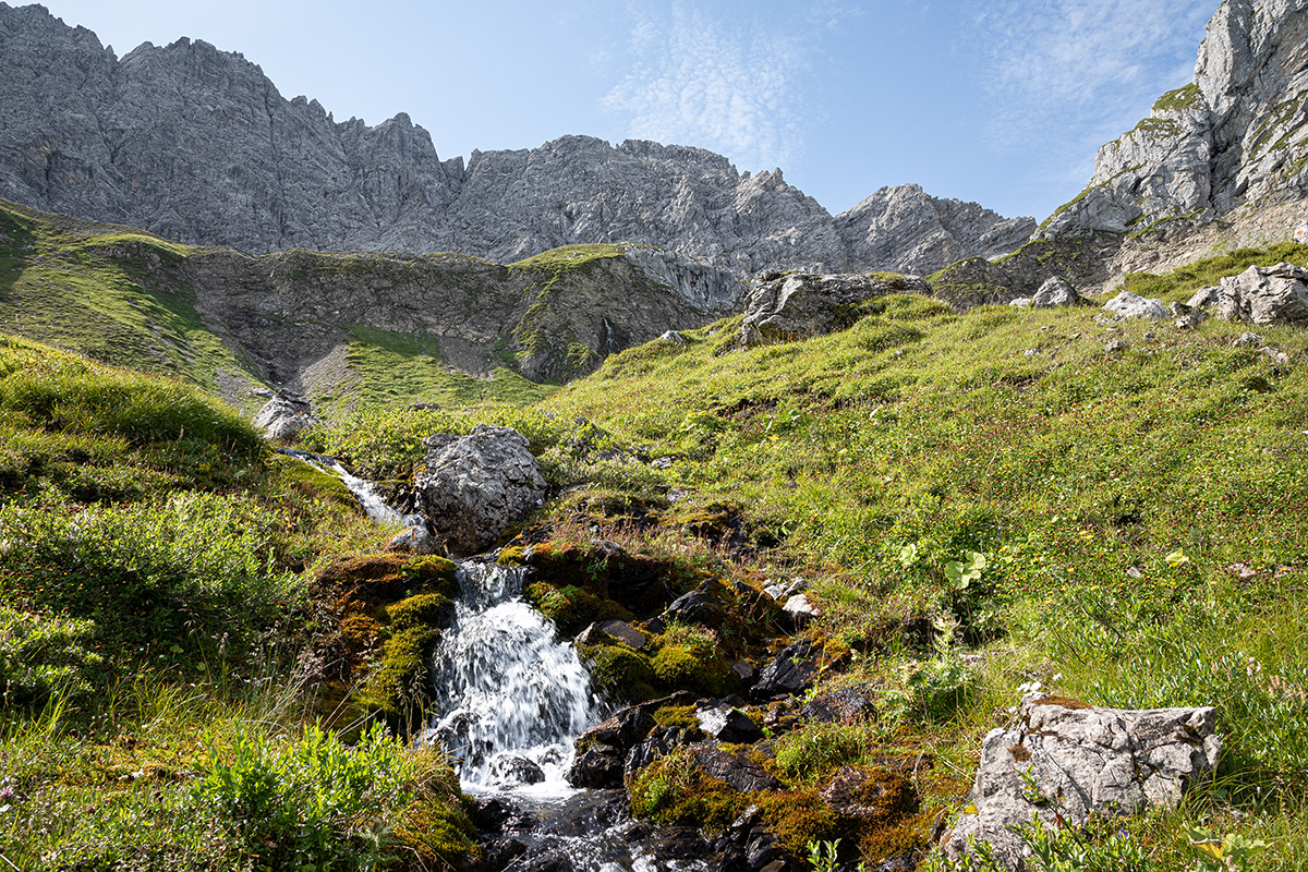 Fluss, der durch die Berge fließt. Dahinter steinerne Berge.